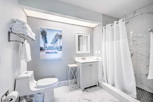 a white bathroom with a toilet and a sink at Orlando Family Condo about 9 Mi to Magic Kingdom! in Orlando