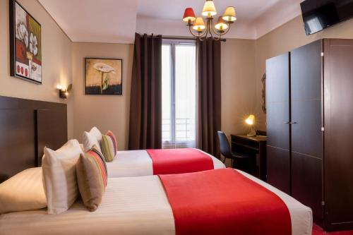 a hotel room with two beds and a desk at Chatillon Paris Montparnasse in Paris