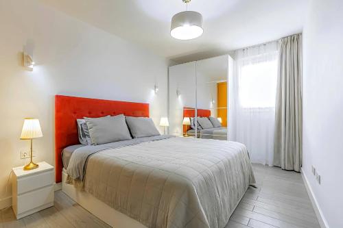 a bedroom with a large bed with an orange headboard at 2-bed AMAZING OCEAN VIEW APARTMENT Costa Adeje in Adeje