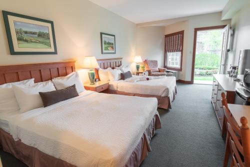 a hotel room with two beds and a television at Rodd Brudenell River Resort in Cardigan