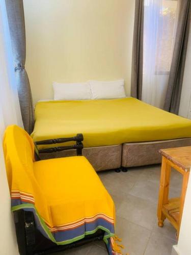 蒙巴薩的住宿－Imani’s home，一张黄色的床和一把椅子