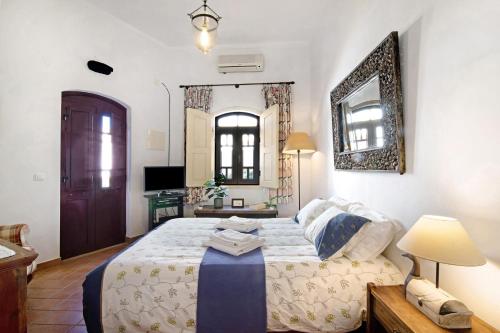 a bedroom with a large bed and a mirror at Casa do Lavrador Furnazinhas in Odeleite