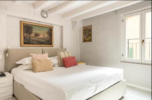 - une chambre blanche avec un grand lit et des oreillers dans l'établissement MMeSuite Arena di Verona by Maisonme Collection, à Vérone