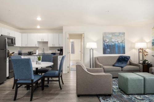 a kitchen and living room with a table and chairs at WaterWalk Extended Stay by Wyndham Minneapolis - Plymouth in Plymouth
