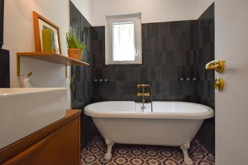 a bathroom with a bath tub and a sink at Cottage Sylvie à 25 minutes Cassis in Roquevaire