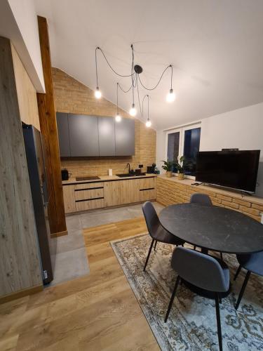 a kitchen with a table and chairs in a room at Apartamenty Osmolice w Stawach in Dęblin