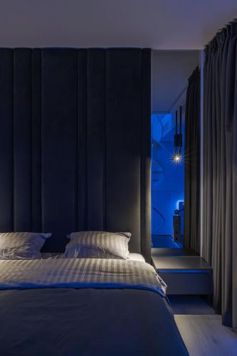 a blue bedroom with a bed and a window at The Penthouse Kyiv in Kyiv