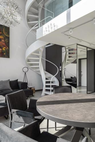 a spiral staircase in a room with a table and chairs at The Penthouse Kyiv in Kyiv