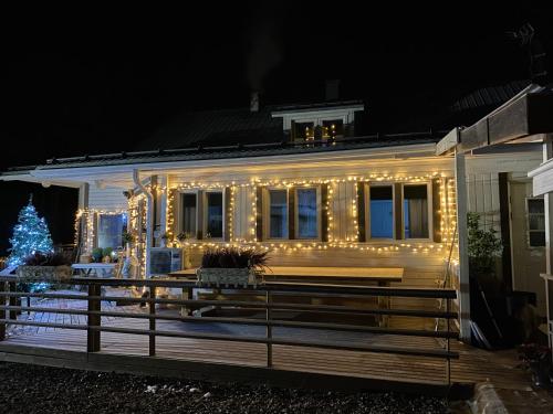 a house decorated with christmas lights and a christmas tree at Villa Shaman in Rovaniemi