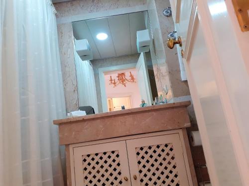 a bathroom with a sink and a mirror at One bedroom apartement with sea view shared pool and enclosed garden at Sao Martinho Funchal in Funchal