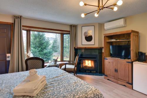 ein Schlafzimmer mit einem Bett und einem Kamin in der Unterkunft Hotel Le Petit Lac Sainte-Adèle in Sainte-Adèle