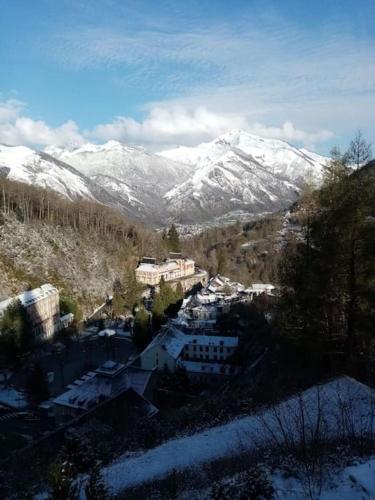 - une vue sur une ville avec des montagnes enneigées dans l'établissement Appartement Lumineux et Rénové dans les Pyrénées, à Eaux-Bonnes