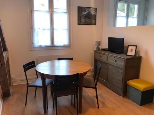 ein Esszimmer mit einem Holztisch und Stühlen in der Unterkunft Appartement Lumineux et Rénové dans les Pyrénées in Eaux-Bonnes