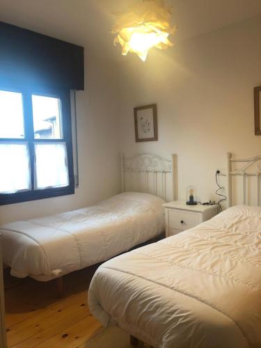 a bedroom with two beds and a window at Las Raucas in Colombres