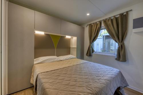 a bedroom with a bed and a window at Camping Eden Glamping in Dormelletto