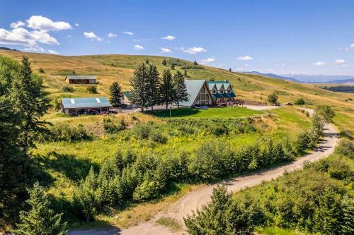 an aerial view of a house on a hill with a dirt road at A-Frame Home with Breathtaking Views and Hot Tub! in Bozeman