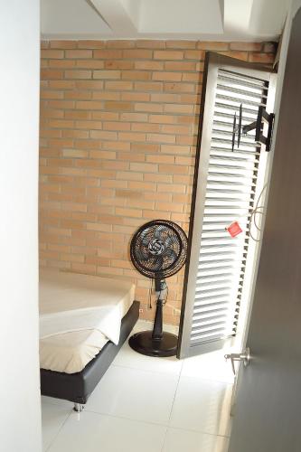 a room with a fan next to a brick wall at Hotel Santo llanero in Palmira