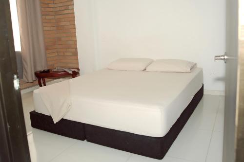 uma cama num quarto com um colchão branco em Hotel Santo llanero em Palmira