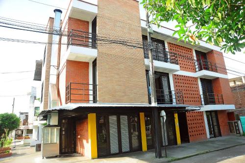 a red brick building with black and yellow doors at Hotel Santo llanero in Palmira