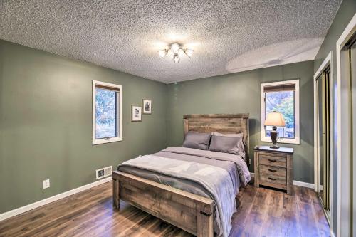 een slaapkamer met groene muren en een bed met een houten hoofdeinde bij Peaceful Cottage with Mtn View Near ATV Trails! in Welch