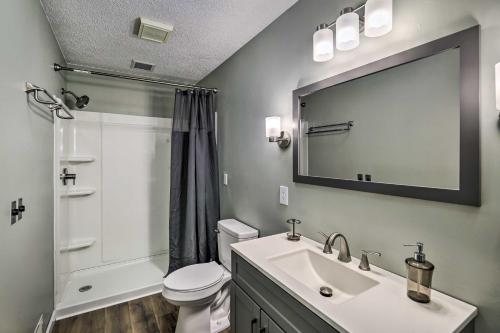een badkamer met een wastafel, een toilet en een spiegel bij Peaceful Cottage with Mtn View Near ATV Trails! in Welch