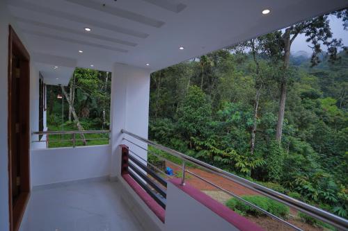 a balcony with a view of the forest at God's gift in Devikolam