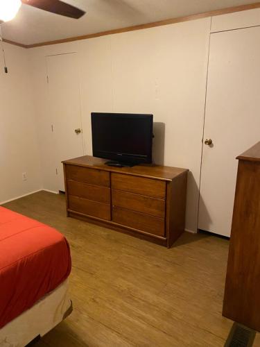 a bedroom with a tv on a wooden dresser at Edgewater Getaway in Port Lavaca