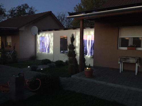 a house with blue lights in the windows at night at Kökszi Beach Nyaralóházak in Balatonszabadi