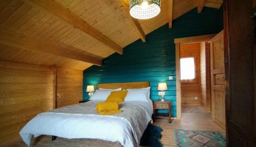 1 dormitorio con paredes verdes y 1 cama con almohadas amarillas en Casa rural El Bujo, en Solana de Ávila