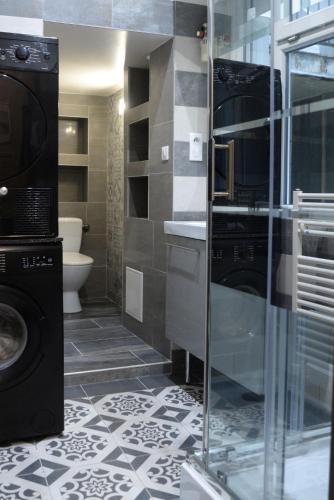 a bathroom with a sink and a washing machine at Le Stanislas, un style! in Nancy