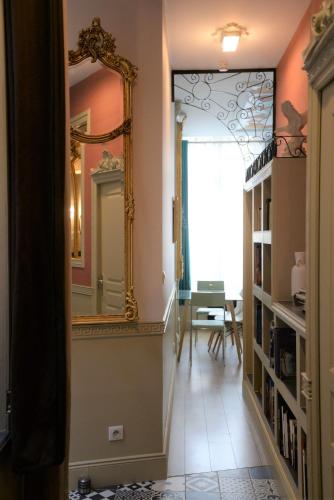 un couloir avec un grand miroir et une table dans l'établissement Le Stanislas, un style!, à Nancy