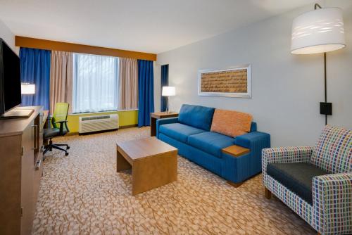 a living room with a blue couch and a chair at Holiday Inn Express & Suites Ft. Washington - Philadelphia, an IHG Hotel in Fort Washington