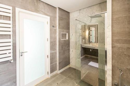 a bathroom with a walk in shower and a mirror at Duplex avec piscine Détente et élégance in Gammarth