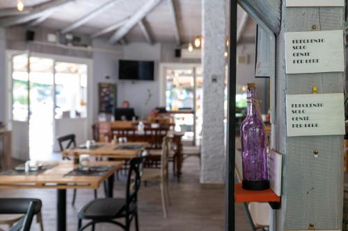 a restaurant with wooden tables and a purple bottle on a shelf at Camping Eden Glamping in Dormelletto