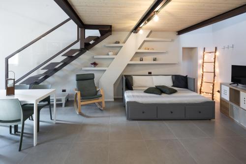 een slaapkamer met een bed, een tafel en een trap bij A Casa di BiaGio in Rapolano Terme
