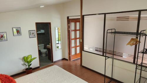 a living room with a glass door and a bathroom at La Guayaba Monteverde in Monteverde Costa Rica