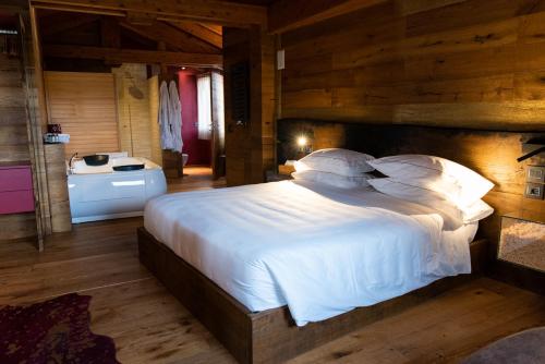 a bedroom with a large white bed with wooden walls at Locanda Sensi in Rivergaro