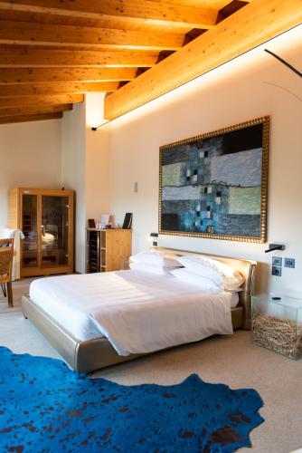 a bedroom with a large white bed and a blue rug at Locanda Sensi in Rivergaro
