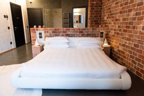 a large bed in a brick walled room at Locanda Sensi in Rivergaro