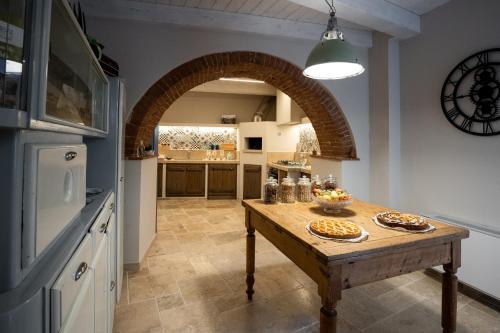 a kitchen with a wooden table and an archway at A Casa di BiaGio in Rapolano Terme