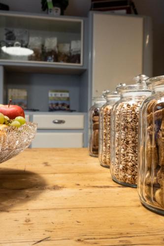 a table with jars filled with nuts and a bowl of fruit at A Casa di BiaGio in Rapolano Terme