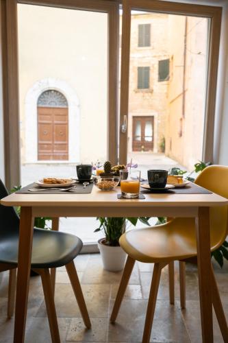 a table with plates of food on it in a room with a window at A Casa di BiaGio in Rapolano Terme