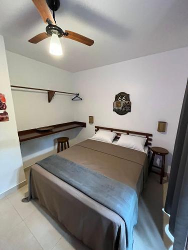 a bedroom with a bed and a ceiling fan at Residencial Villa Cris - Jd. São Lourenço/Itaguaré in Bertioga