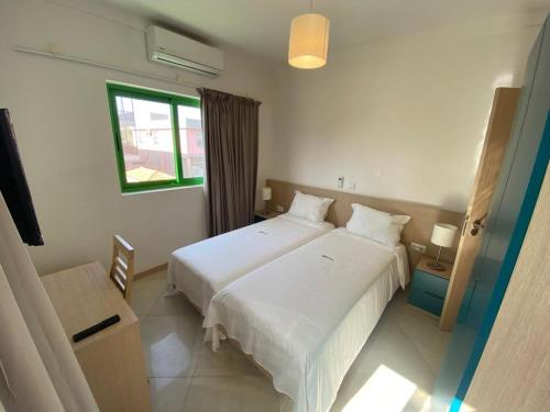 um quarto com 2 camas brancas e uma janela em Hotel NHATERRA em Santa Maria