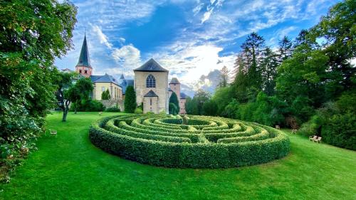 un gran laberinto de setos frente a un castillo en Kloster Steinfeld Gästehaus en Kall