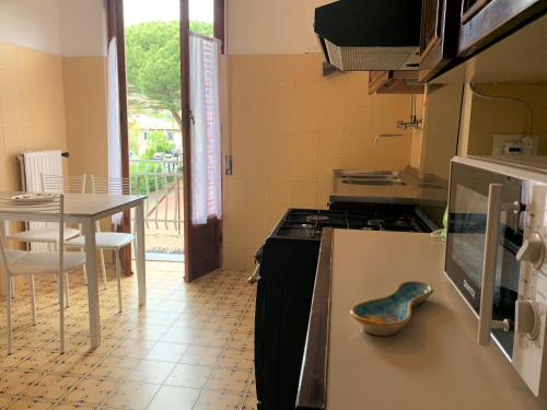 een keuken met een tafel en een fornuis top oven bij Lella appartamenti con parcheggio in Levanto