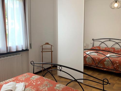 een slaapkamer met 2 bedden, een tafel en een raam bij Lella appartamenti con parcheggio in Levanto