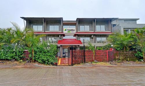 a building with a red gate in front of it at Treebo Trend Paradise Inn Panchgani in Mahabaleshwar