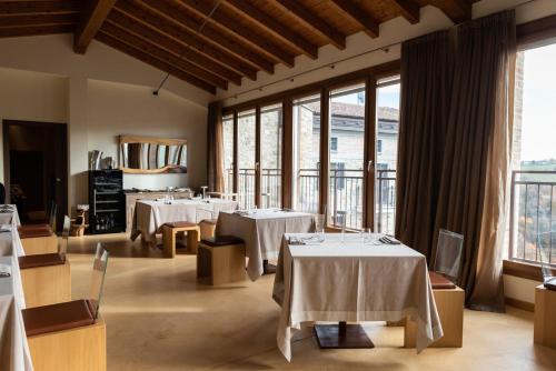 a restaurant with tables and chairs and large windows at Locanda Sensi in Rivergaro