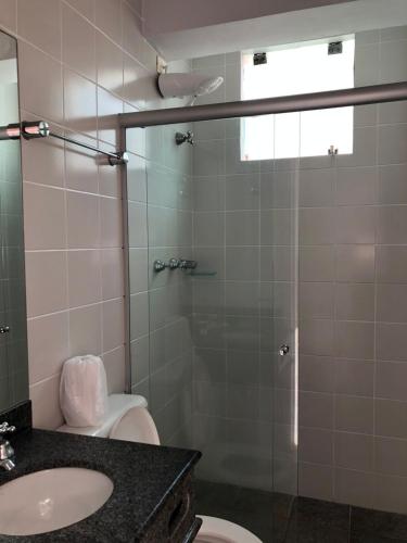 a bathroom with a shower and a toilet and a sink at HOTEL ENSEADA BEIRA MAR in Guarujá